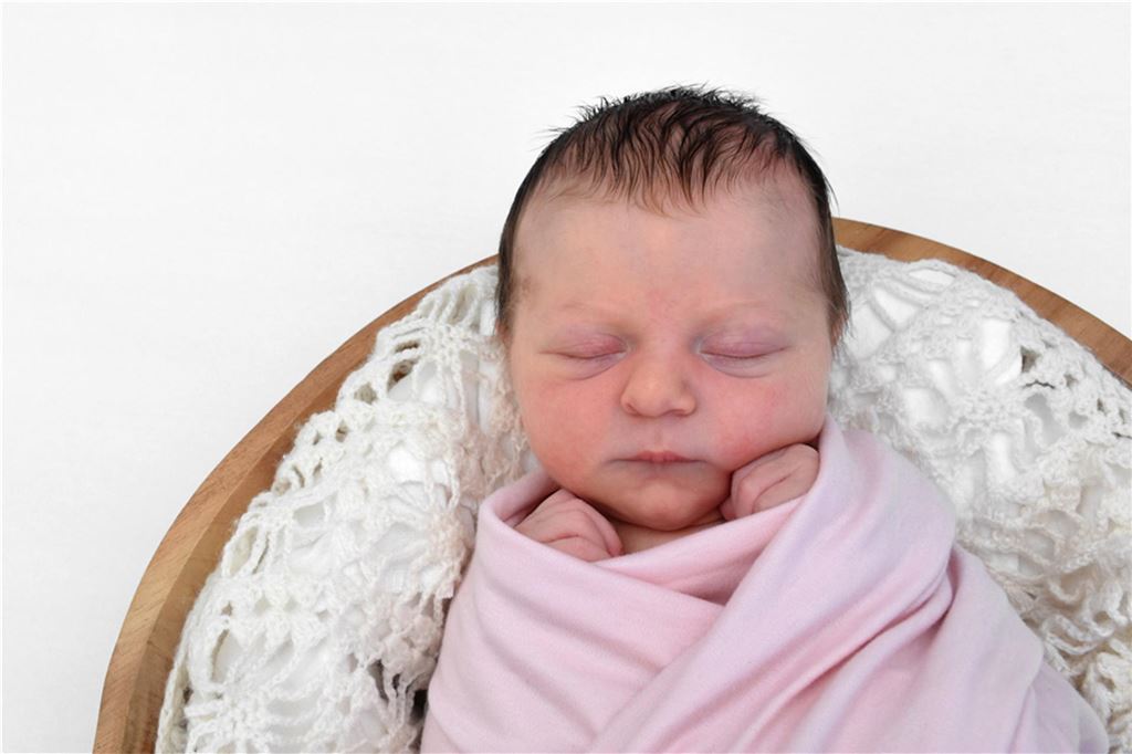 Leni, Elias und Co.: Unnas beliebteste Babynamen im Jahr 2024 Ein neu geborenes Baby schläft in eine rosafarbene Decke eingewickelt