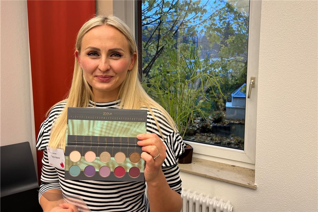 Kosmetikseminar für Krebspatientinnen: Ein Stück Alltag in schweren Zeiten Die Kosmetik-Expertin Tanja Haberer hält lächelnd eine Lidschatten-Palette in die Kamera.
