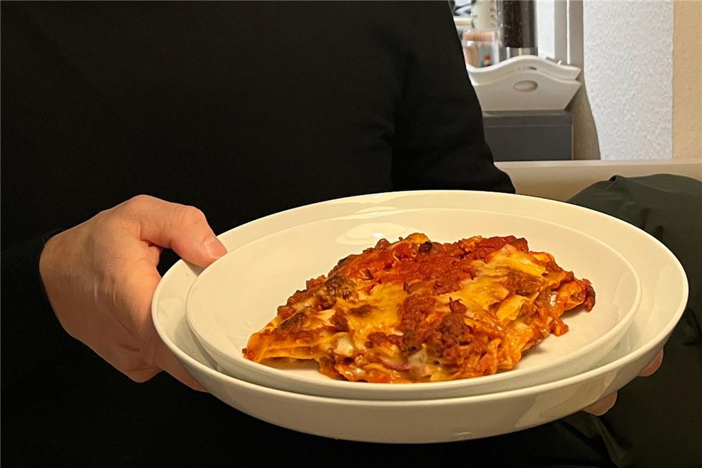 Wenig zu meckern beim Restaurant-Test von Billy Reinas Bistro „SiSi“ Ein Gast hält im Bistro SiSi in Unna einen Teller mit einem Stück Lasagne.
