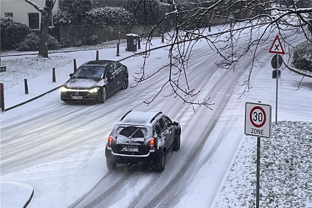 Unfälle durch Schnee und Glätte am Abend im Kreis Unna Autos fahren in Unna über eine verschneite Straße