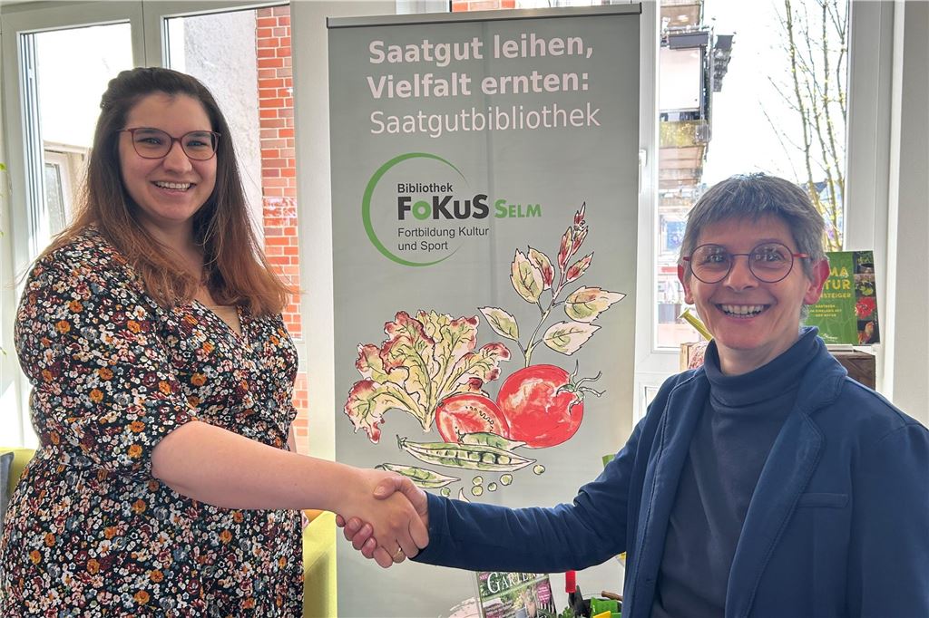 Julia Katthöfer übernimmt Leitung der Bibliothek Julia Katthöfer und Margit Breiderhoff geben sich die Hand und lächeln in die Kamera.