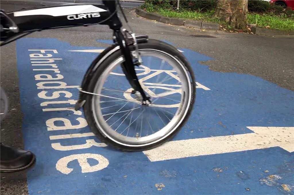 Afferder Weg: Schwierige Verkehrsplanung mit Pannen und Wendemanövern Das Bild zeigt das Vorderrad eines Fahrrads, das auf einem Piktogramm mit dem Hinweis Fahrradstraße steht.