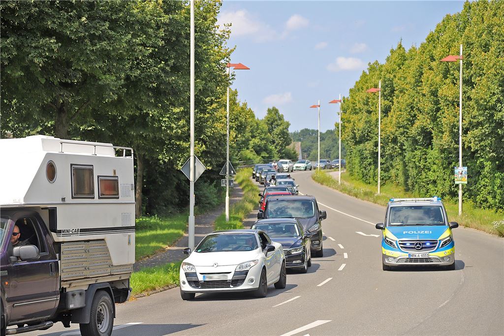 Ein Polizeiauto fährt an einer Autoschlange in Fröndenberg vorbei.