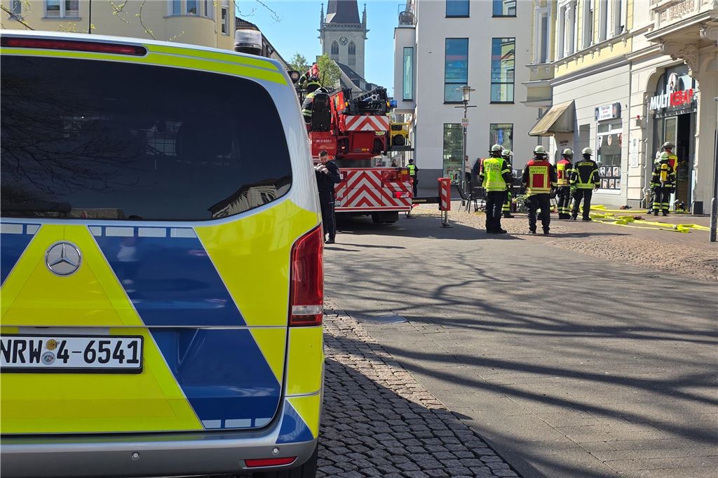 Feuerwehreinsatz in der Innenstadt von Unna: Pizzaofen in Imbiss fängt Feuer Ein Polizeiauto, ein Feuerwehrfahrzeug und Feuerwehrleute stehen vor dem Imbiss Multi Kebap in der Bahnhofstraße in Unna
