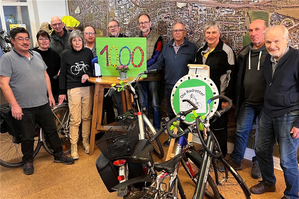 Mit 10 Euro und einer Klingel in die Selbstständigkeit Eine Gruppe Erwachsener steht hinter Fahrrädern und einem grünen Plakat mit der Aufschrift "1000"