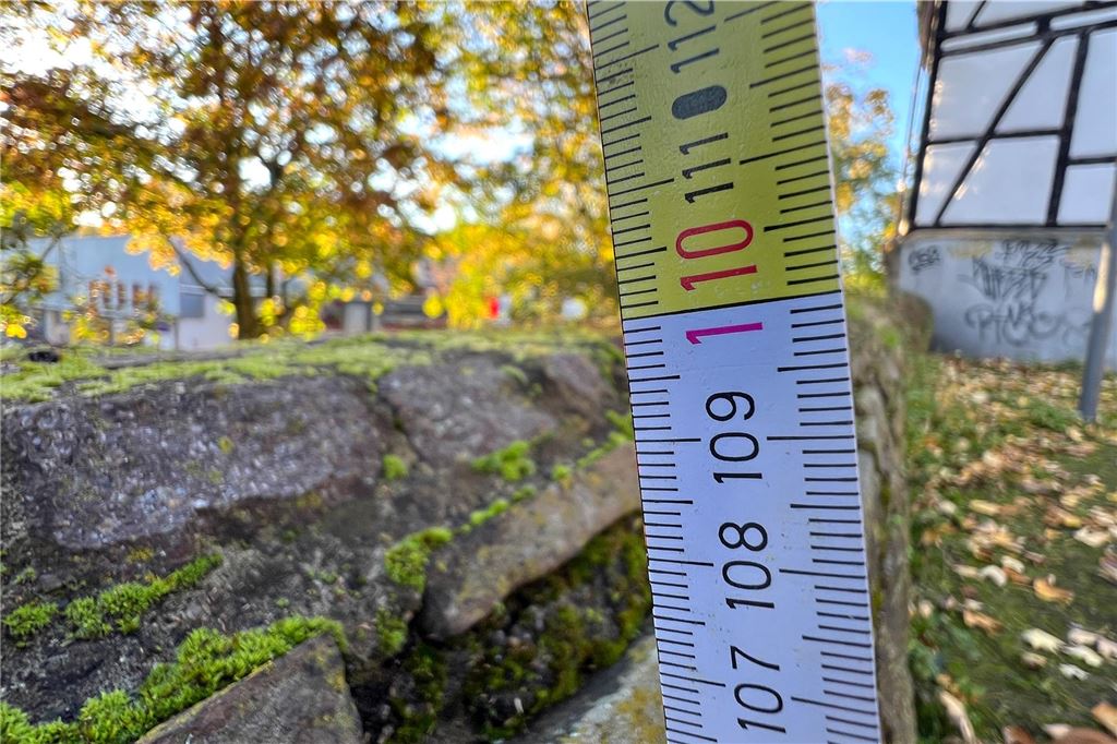 Björn Merkord (53) sieht gefährliche Stelle am Radring Ein Zollstock zeigt, dass die Stadtmauer an der Voßkuhle in Unna rund 110 Zentimeter hoch ist.