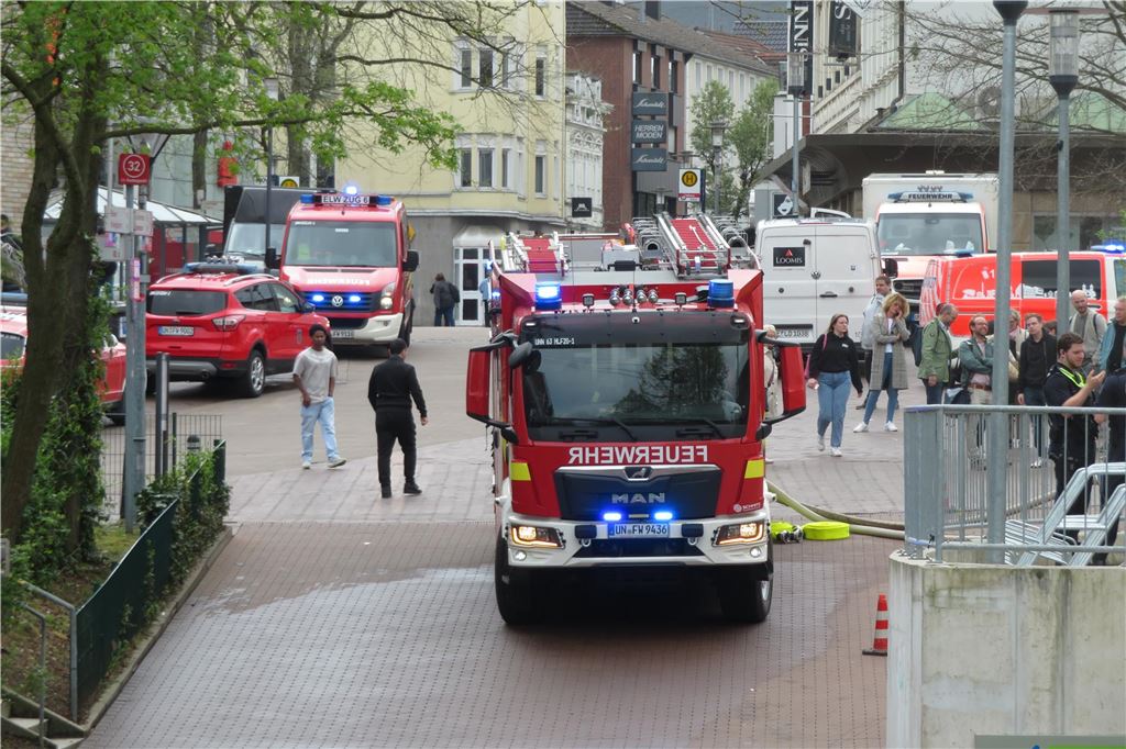 Feuerwehr in der Innenstadt: Brand im Dachstuhl neben Einkaufszentrum Feuerwehrfahrzeuge stehen zwischen dem Einkaufszentrum Neue Mühle und dem Rathaus in der Innenstadt von Unna.