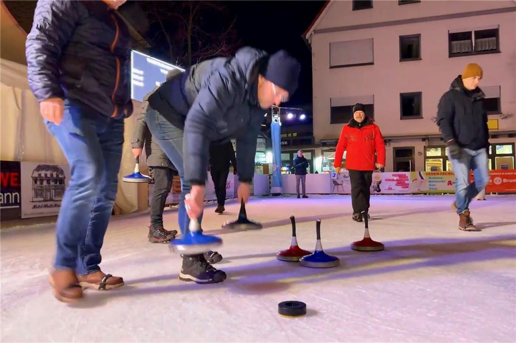 Eisstockschießen 2024: Auslosung der Teams ist gelaufen Männer und Frauen auf einer Eisfläche mit Eisstöcken.