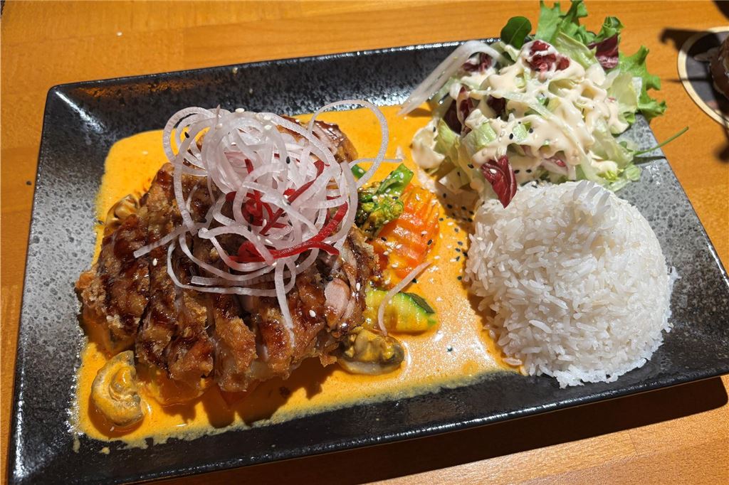 Lido im Restaurant-Check: Vietnamesische Vielfalt mit Liebe zum Detail Auf einem Teller ist das Gericht „Golden Curry Crispy Duck“ im Lido in Unna angerichtet. Eine knusprige Ente liegt auf Gemüse in einer Sauce. Daneben liegen Salat und Reis.