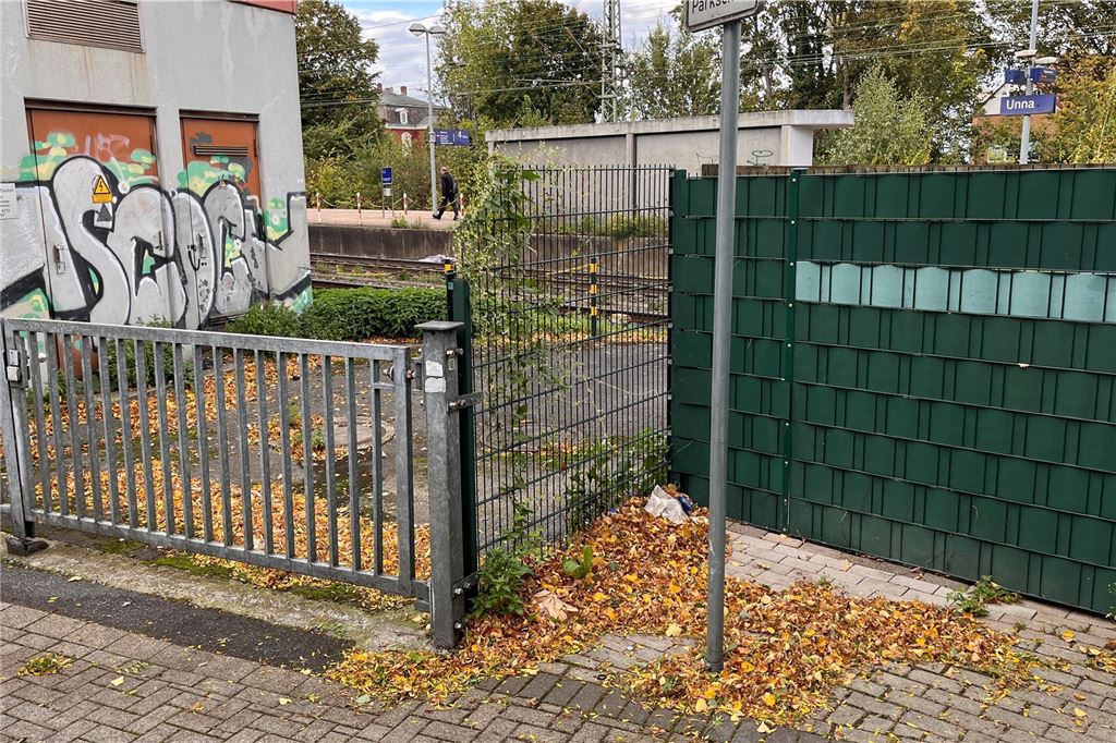Lebensmittelhändler ruft um Hilfe wegen Trinkerszene Im Umfeld des Bahnhofs in Unna sind Graffiti an einer Gebäudewand. Davor stehen Zäune, rundherum liegt Laub