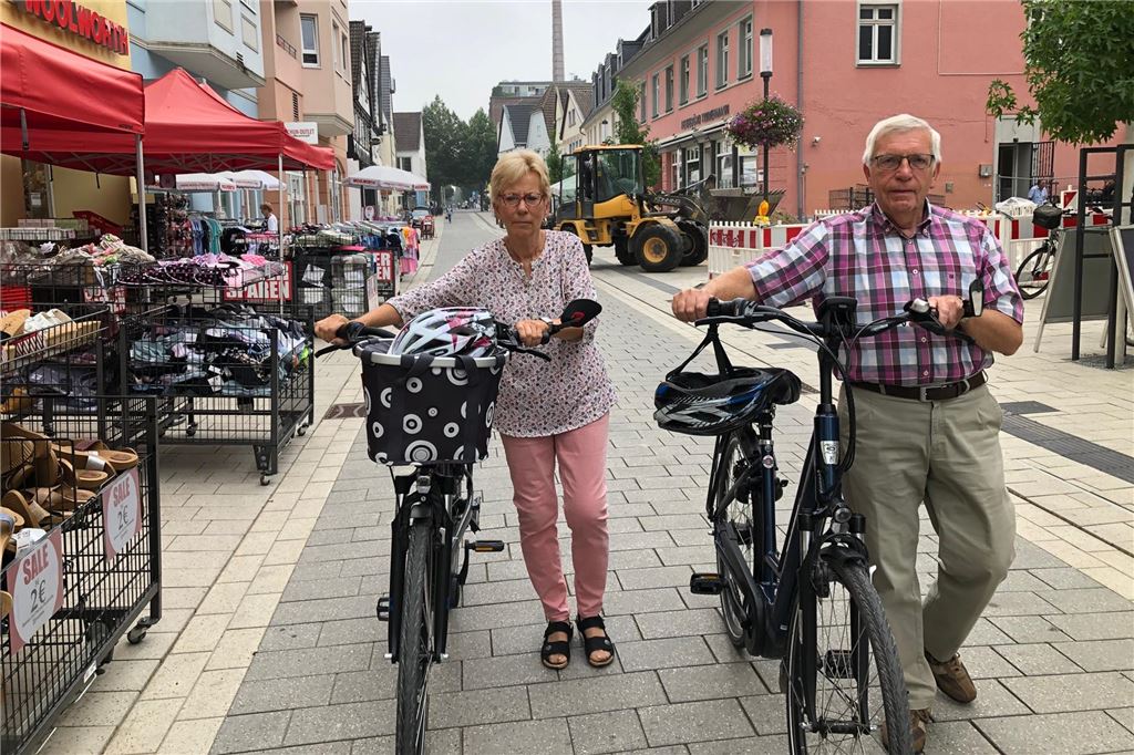Das neue Fahrradverbot in der Fußgängerzone ist umstritten Eine Frau und ein Mann schieben Fahrräder durch die Fußgängerzone in Unna