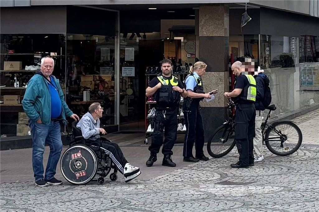 Fahrradverbot in Fußgängerzone hat auch Befürworter Auf dem Markt in Unna stehen drei Polizisten neben einem Fahrradfahrer. Daneben schiebt ein Mann eine Person in einem Rollstuhl.