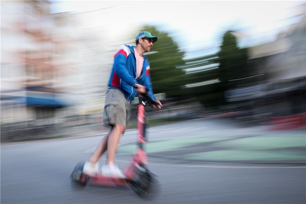 E-Scooter: Unternehmen melden Interesse an Ein Mann ist auf einem E-Scooter unterwegs.
