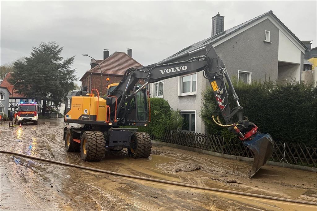 Ein Bagger ist zu Hilfe geeilt, um den Schlamm von der Straße zu kratzen.