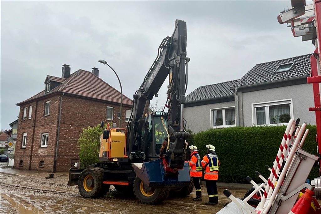 Ein Bagger ist zu Hilfe geeilt, um den Schlamm von der Straße zu kratzen.