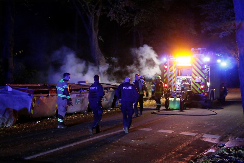 GWA reagiert auf Brände und Vermüllung: Altkleider-Container ziehen um Aufnahme von der Feuerwehr, die im Dunklen den Container an der Unnaer Straße löscht. Rauch steigt auf und wird von dem hellen Licht des Feuerwehrautos sichtbar gemacht.