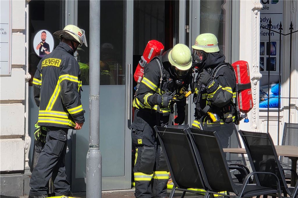 Einsatzkräfte der Feuerwehr stehen vor Imbiss in Bahnhofstraße in Unna