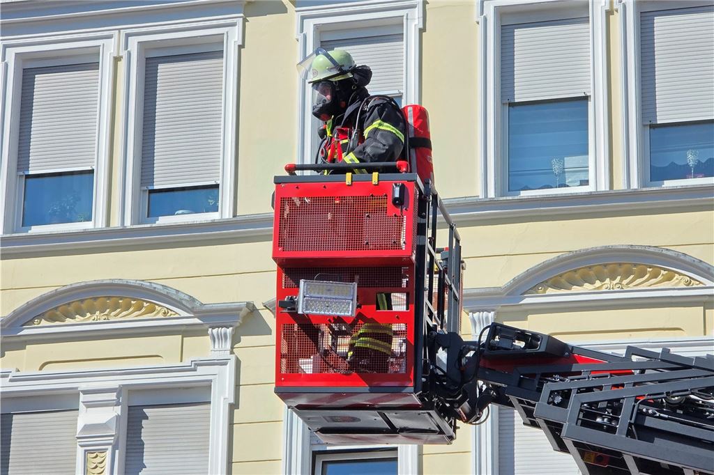 Feuerwehrmann fährt mit Drehleiter nach oben