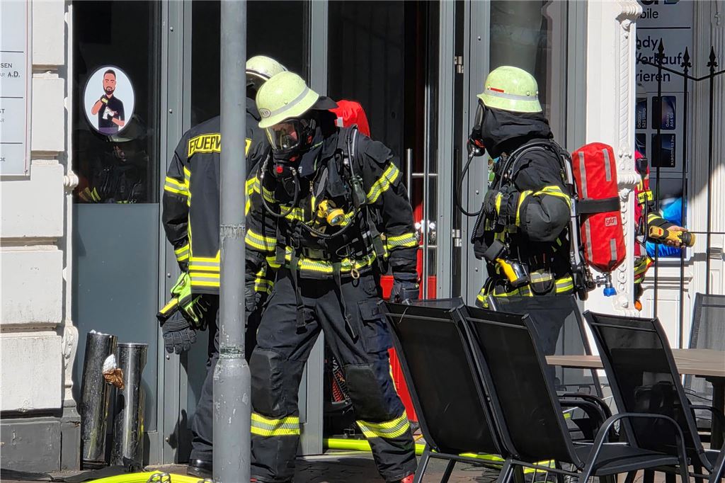 Einsatzkräfte der Feuerwehr stehen vor Imbiss in Bahnhofstraße in Unna