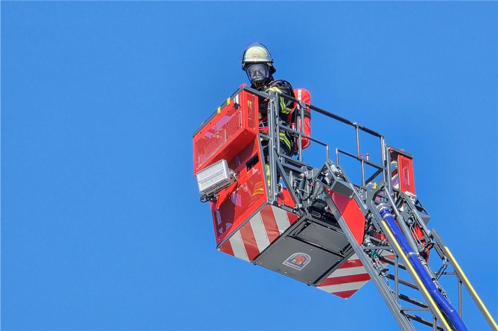 Feuerwehrmann fährt mit Drehleiter nach oben