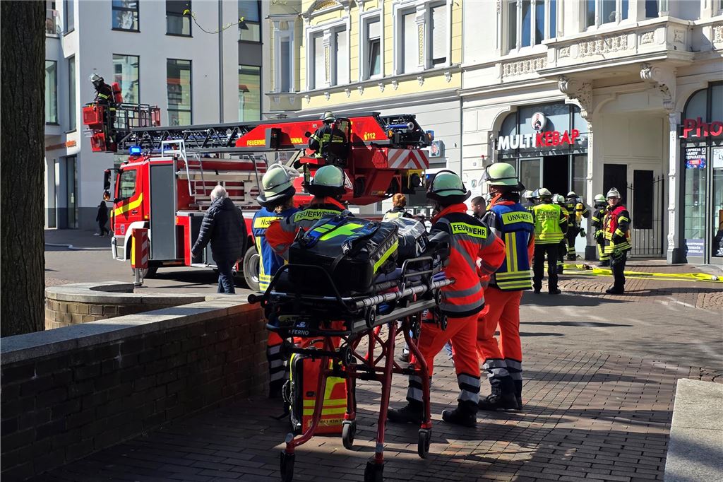 Team an Rettungsleuten steht vor einem Imbiss in der Bahnhofstraße in Unna mit Trage bereit