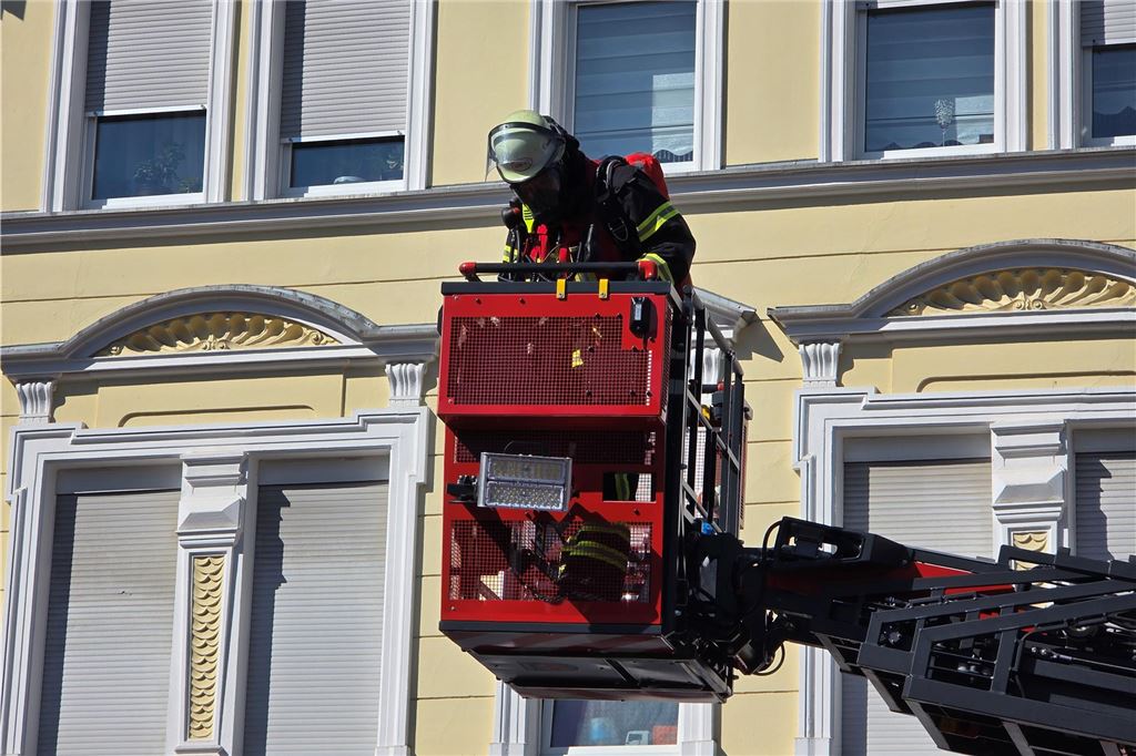 Feuerwehrmann fährt mit Drehleiter nach oben