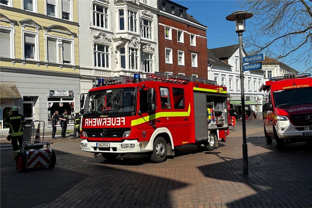 Mehrere Fahrzeuge der Feuerwehr und Einsatzkräfte stehen in der Bahnhofstraße in Unna