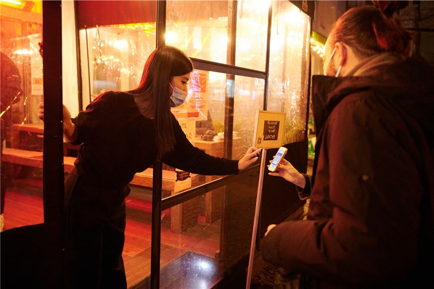 Unklarheit über Corona-Regeln – wird der Kreis Unna zum Hotspot? Eine Mitarbeiterin eines Restaurants kontrolliert den Impfstatus zweier Personen. (Symbolfoto)