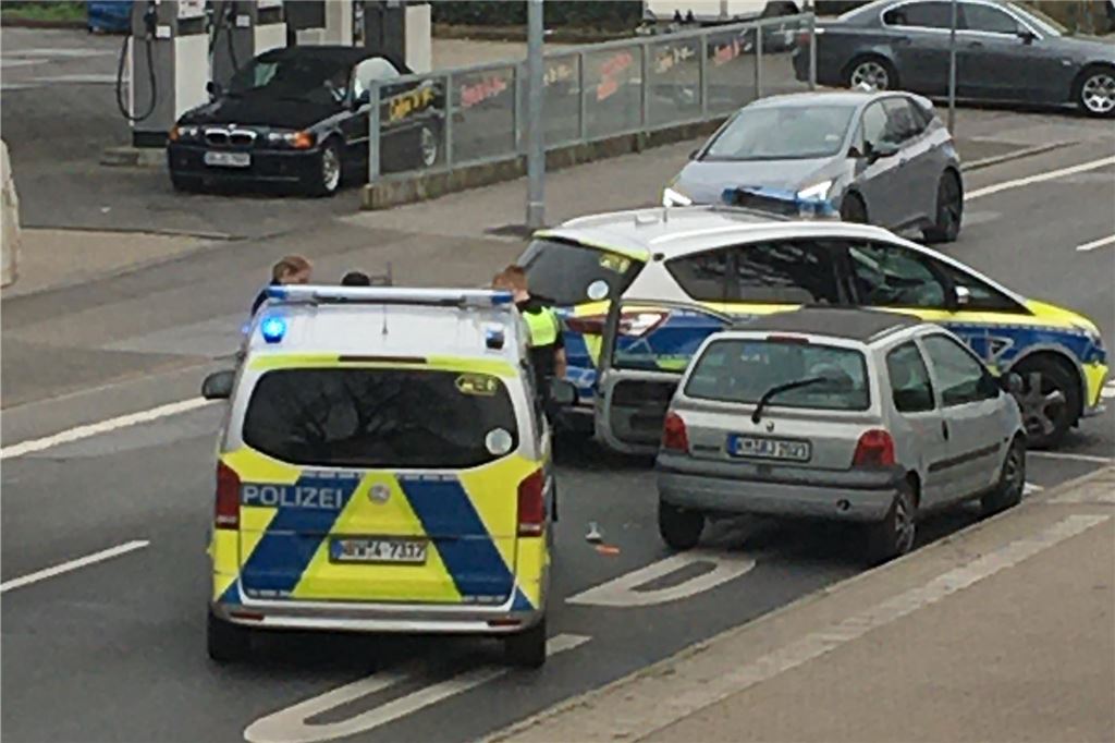 Polizeiautos stehen um ein Auto herum in Dortmund.