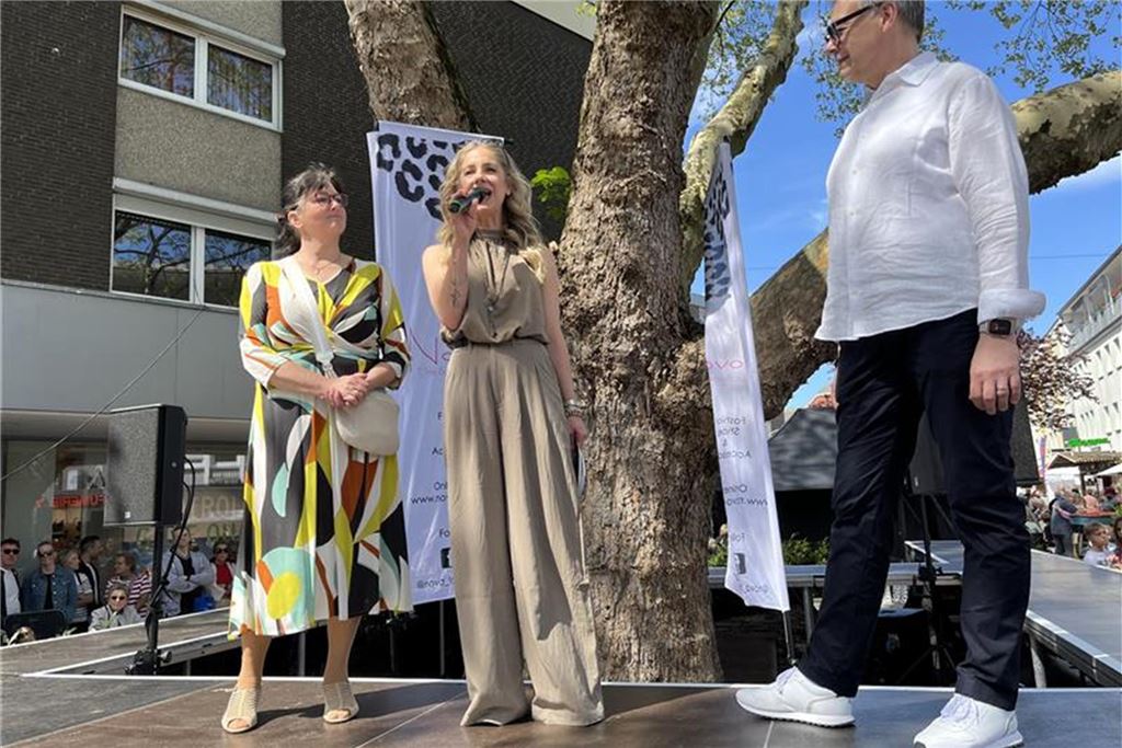 Die schönsten Bilder von „Kamen blüht auf“ Kamens Bürgermeistern Elke Kappen, Sabine Bracke von der Boutique Nova und Stefan Theymann von Optik Schulte auf der Bühne für die Modenschau bei Kamen blüht auf 2025.