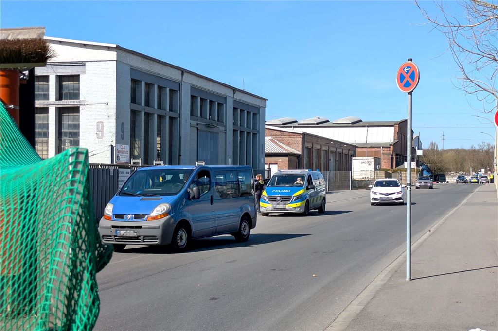 Evakuierung nach Bombenfund: Blindgänger wird kontrolliert gesprengt Autos verlassen um ein Polizeifahrzeug herum ein evakuiertes Gewerbegebiet mit vielen Hallen.