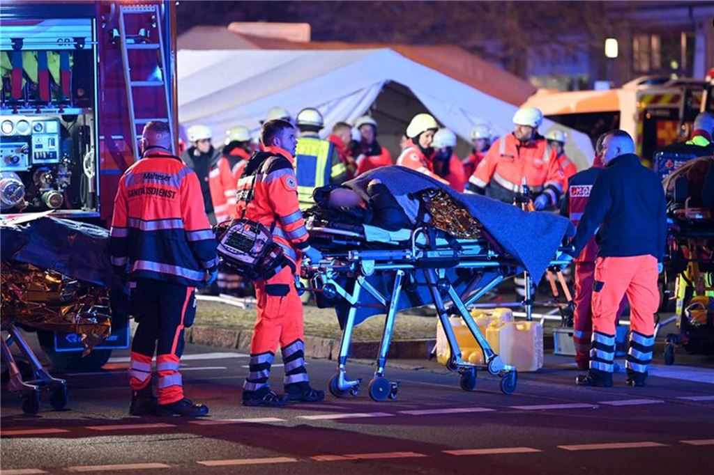 Anschlag auf Magdeburger Weihnachtsmarkt: Fünf Tote, 200 Verletzte - Kanzler Scholz im Livestream Viele Einsatzkräfte, eine Person wird auf einer Trage weggeschoben.