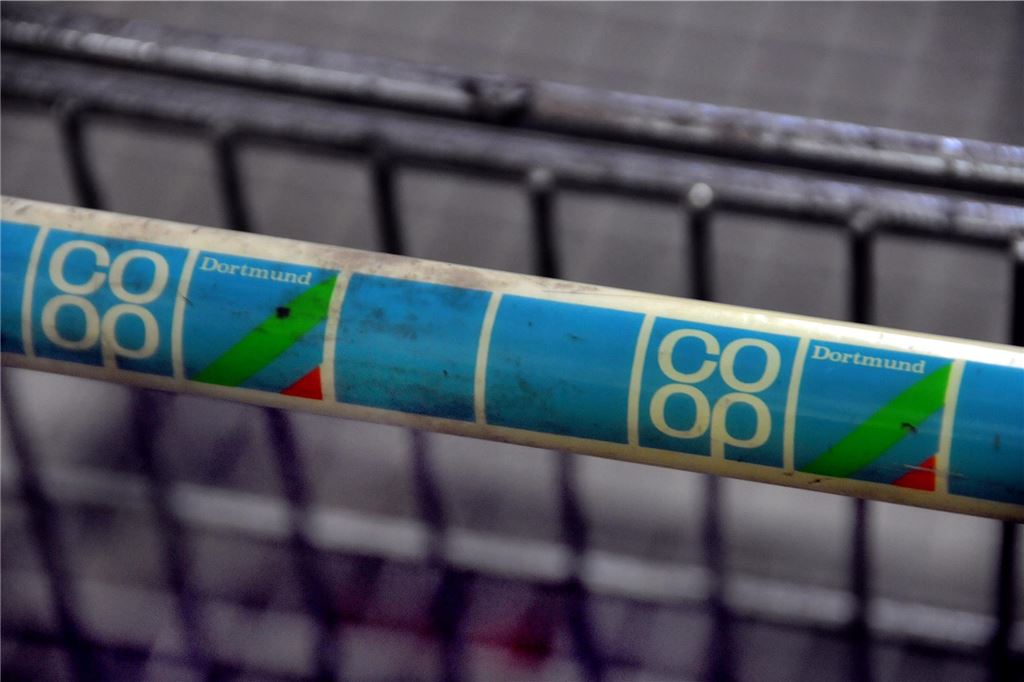 Nach dem Coop-Ende ging es mit dem City-Center bergab Der Griff eines Einkaufswagen mit dem Emblem von Coop Dortmund.