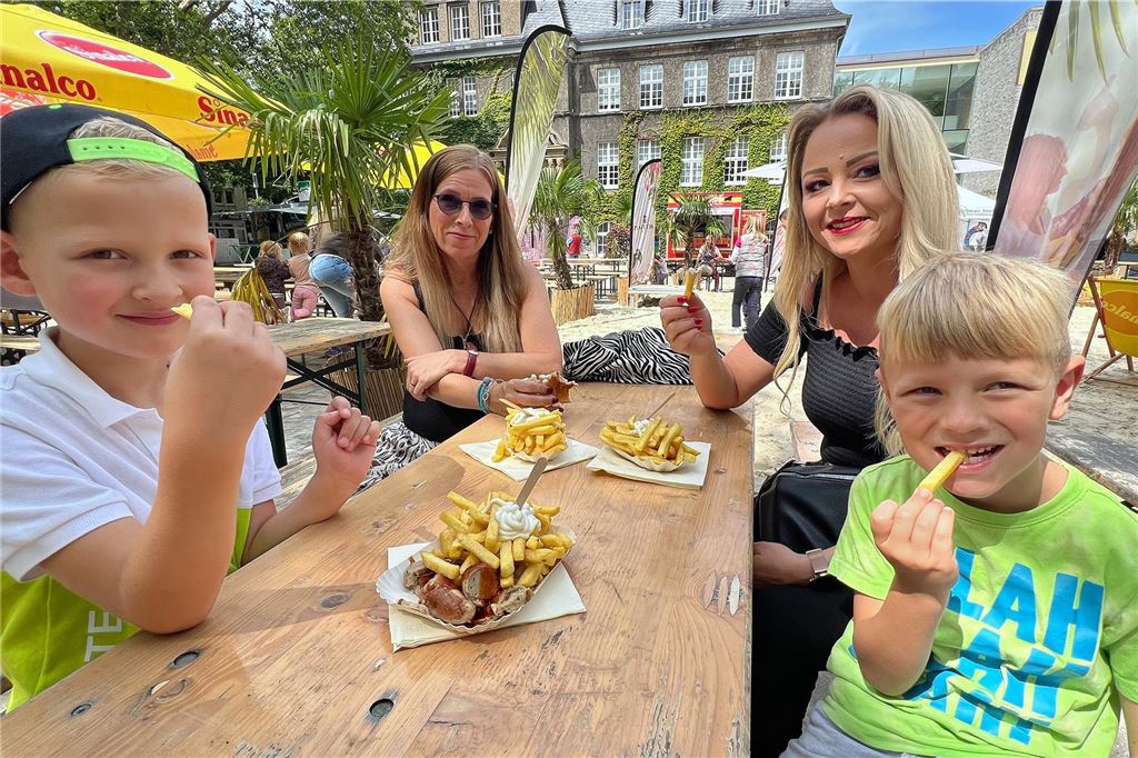 „Holzwickede Karibisch“: Wetter und Inflation trüben beliebtes Fest Zwei Kinder und ihre beiden Mütter beim Pommesessen.