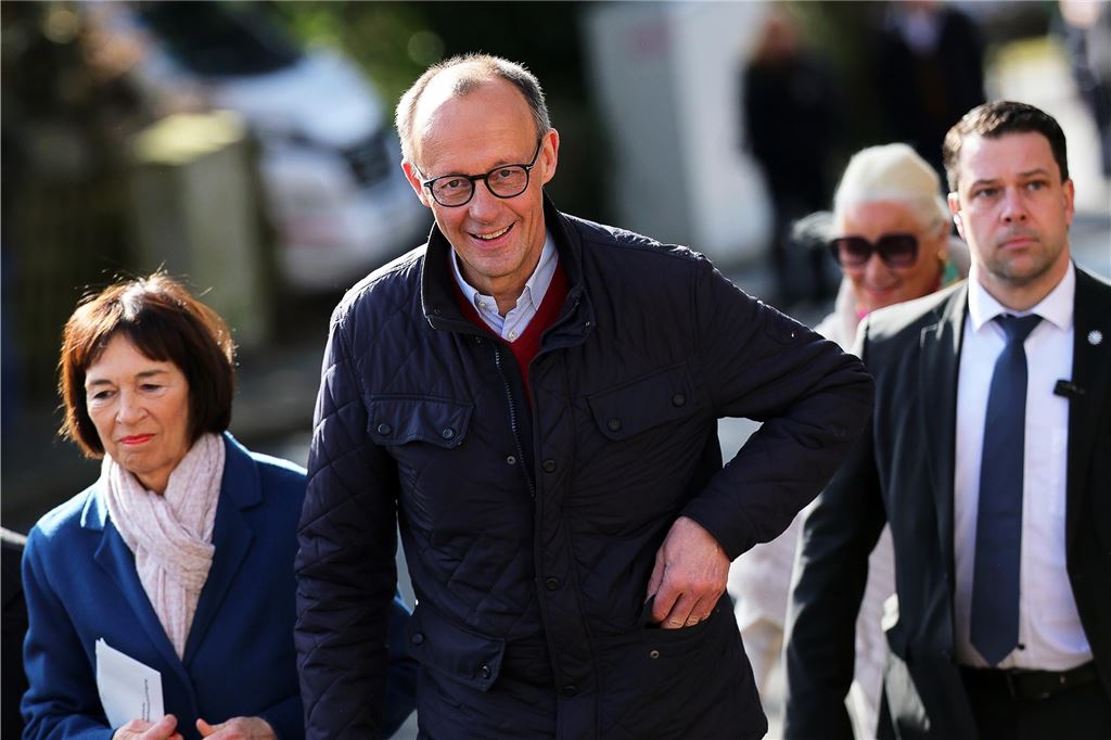Deutschland wählt eine neue Regierung: Der Newsblog zum Bundestagswahltag 2025 Friedrich Merz (CDU, M), Parteivorsitzender und Kanzlerkandidat, und seine Frau Charlotte Merz (l) kommen zur Stimmabgabe ins Wahllokal in der Schützenhalle Arnsberg-Niedereimer.