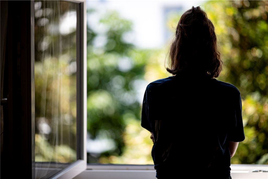 Psychotherapeut zum Neuanfang: „Männer sind Peter Pan, Frauen Cinderella“ Eine Frau steht am Fenster und schaut hinaus.