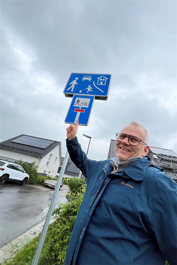 Aufkleber-Ärger: Stadt hängt Straßenschilder in luftiger Höhe auf Holger Heikhaus aus Unna zeigt auf einen besonders hohen Mast am Afferder Weg, der Spielstraßen- und Sackgassen-Schilder trägt.
