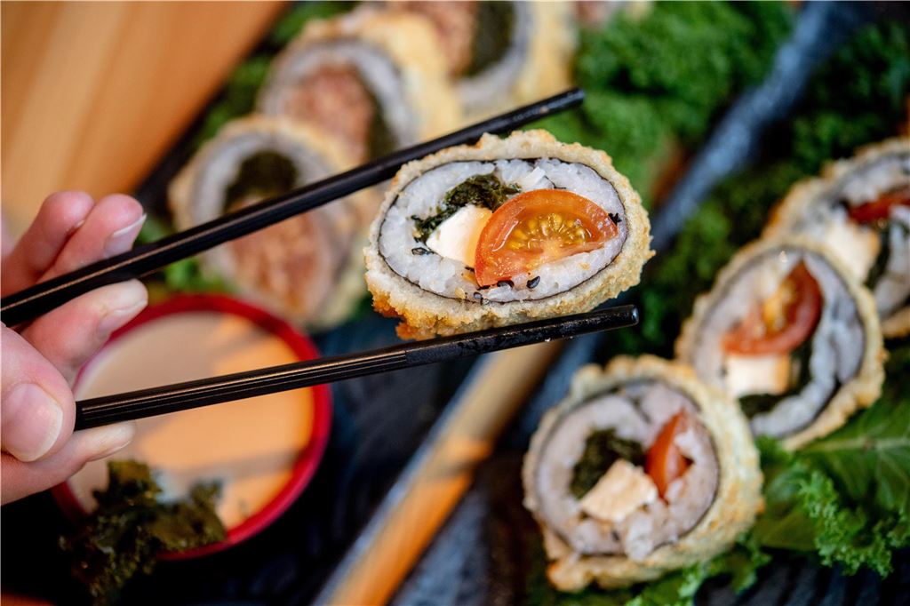 Brasserie wird Lido: Neue Inhaber renovieren Eine Person hält ein Stück Sushi zwischen zwei Essstäben