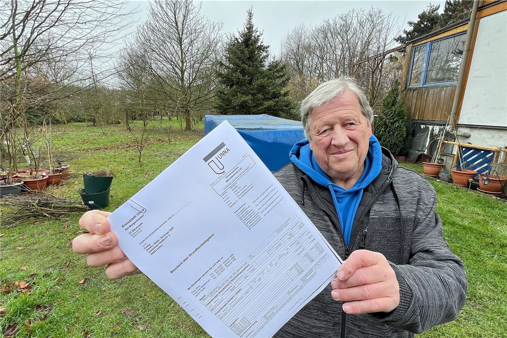 Steuerschock immer extremer: Fast 6000 Euro für Ökozelle Michael Kauke steht auf seiner Streuobstwiese in Unna und hält einen Grundsteuerbescheid in die Kamera.