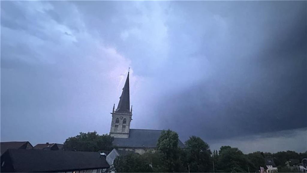 Unwetter beim Public Viewing: Unterbrechung mit Verzögerung Gewitter über Unna. Ein Blitz steht genau über der Kirchturmspitze der Stadtkirche Unna.