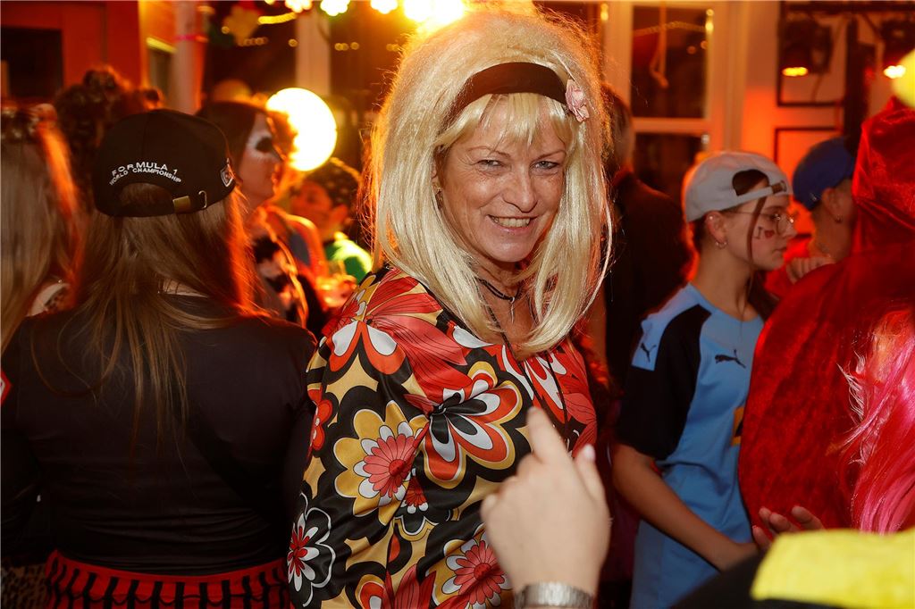 Eine Frau mit blonder Perücke und Hippie-Kleid.