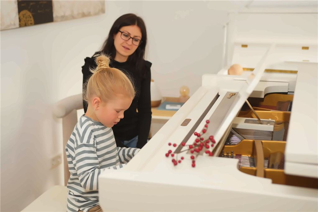 Wunderkind: Hugo (7) komponiert eigene Stücke auf dem Klavier Hugo Selzer sitzt an seinem Flügel der Marke Schimmel und spielt Klavier. Hinter ihm achtet seine Klavierlehrerin Daria Burlak auf seine Technik.