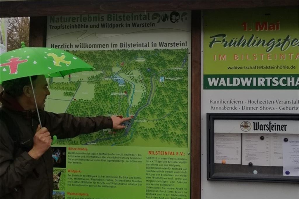 Ausflugstipps: Diese Tierparks in der Nähe haben im Winter geöffnet Ein Mann zeigt mit seinem Zeigefinger auf den Punkt einer Karte des Naturerlebnisses Bilsteintal.