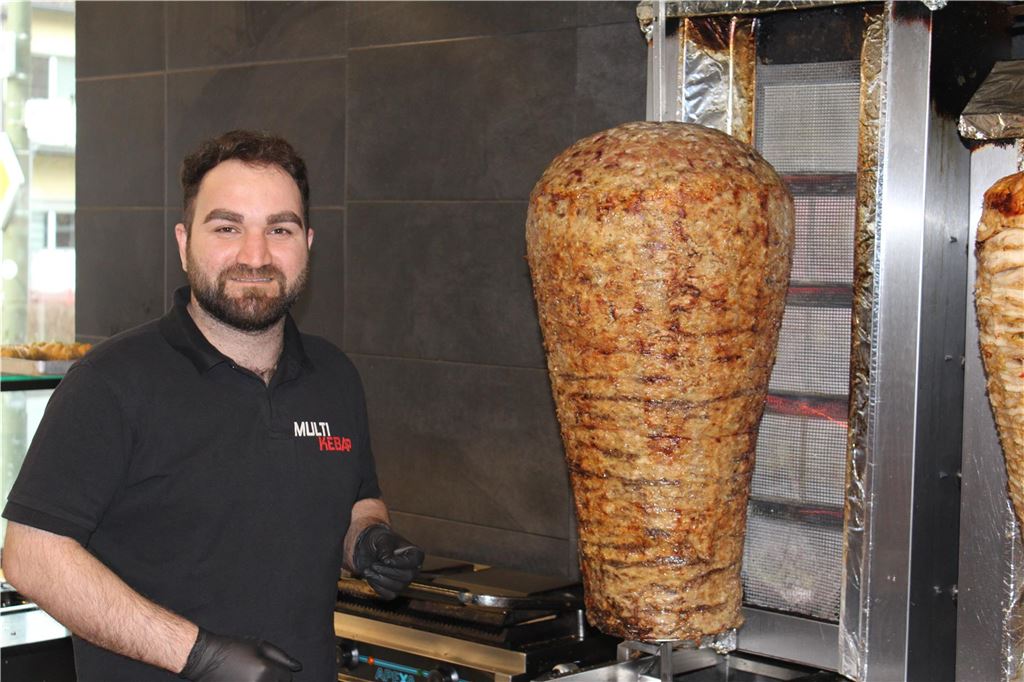 Diese Läden haben 2024 eröffnet und geschlossen Hüseyin Çetin steht in dunkler Arbeitskleidung neben einem Döner-Spieß.