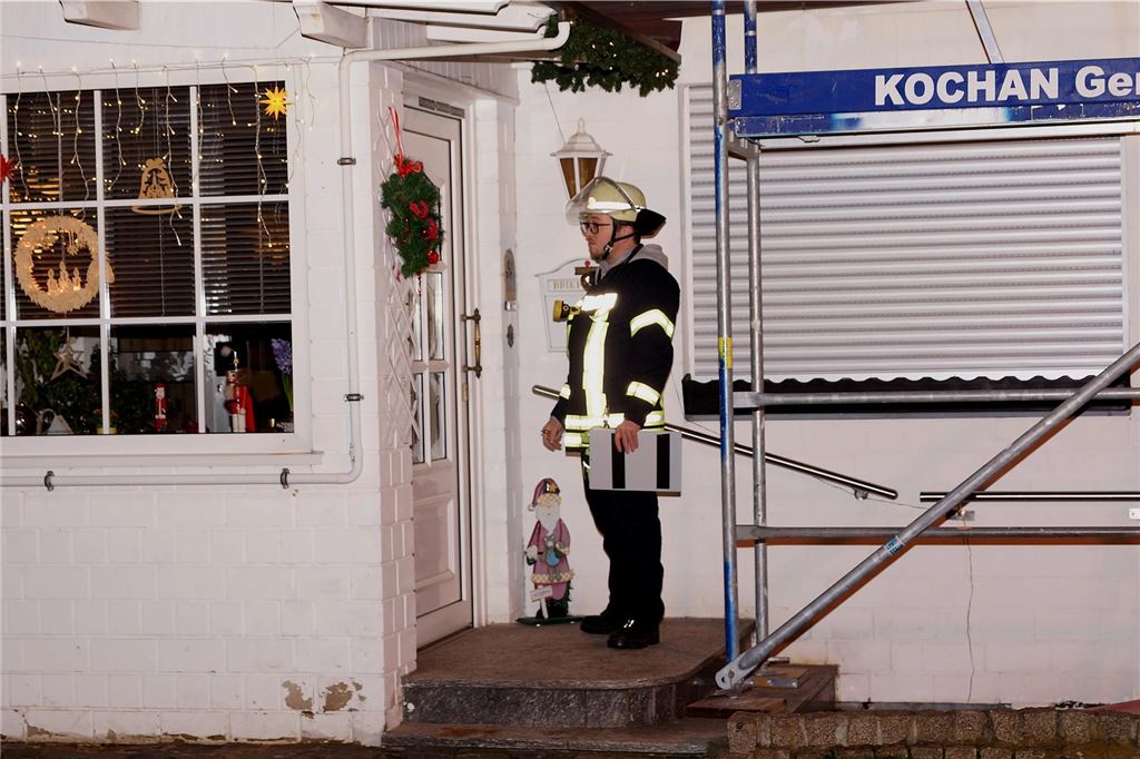 Ein Feuerwehrmann klingelt an einer Haustür im Hortensienweg in Unna-Königsborn.