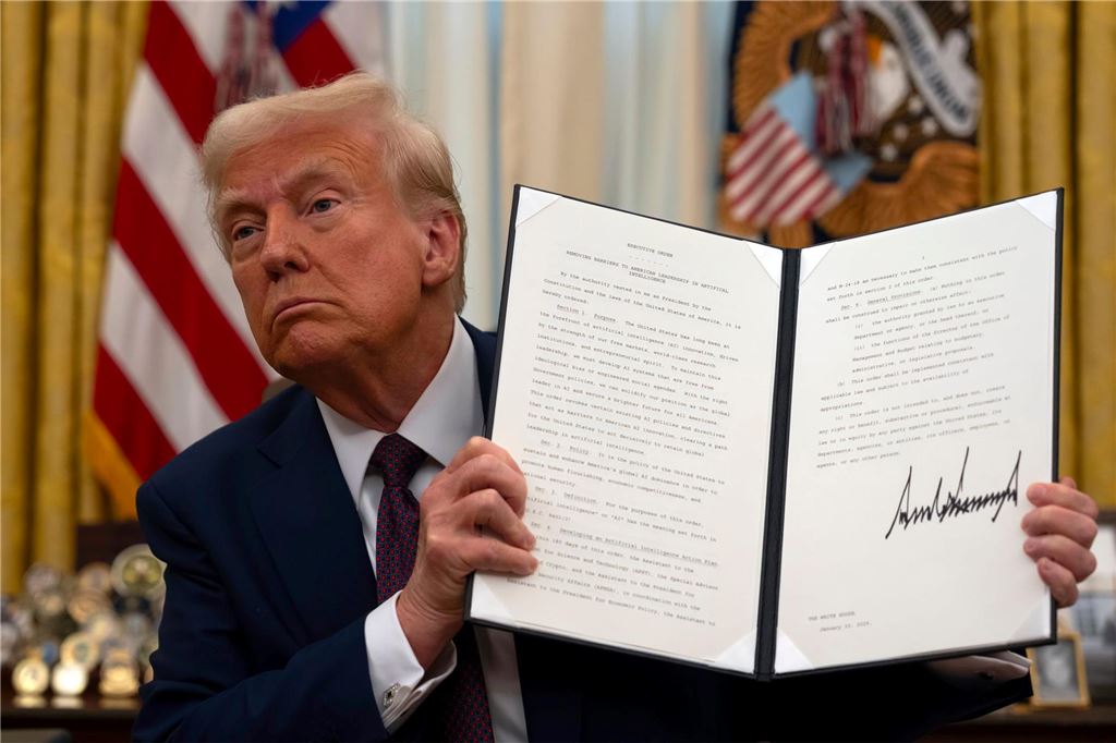 100 Tage Präsident Trump: Eine Auswahl der wichtigsten Entwicklungen US-Präsident Donald Trump hält im Oval Office des Weißen Hauses eine unterzeichnete Anordnung zum Thema künstliche Intelligenz hoch.