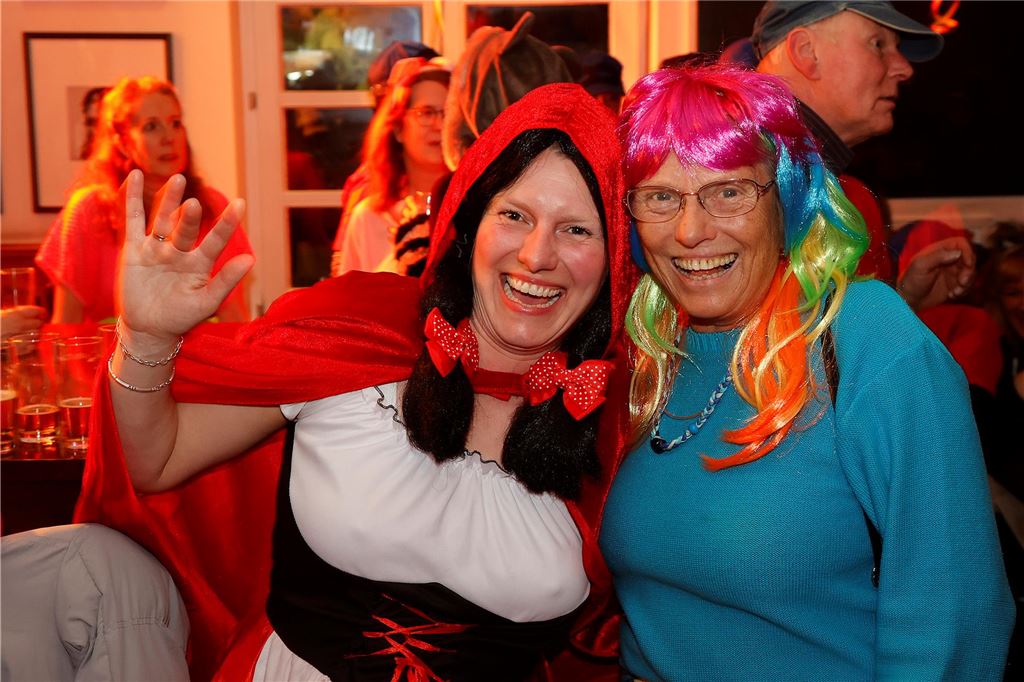 Weiberfastnacht 2025: Die schönsten Bilder des Abends Eine Frau im Rotkäppchen-Kostüm und eine mit bunter Perücke.