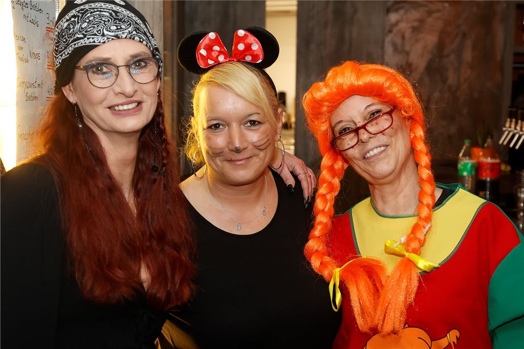 Drei Frauen lächeln in die Kamera, eine ist als Pippi Langstrumpf verkleidet.