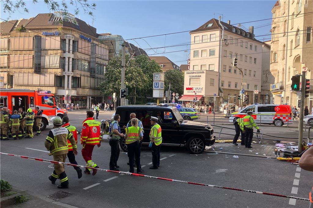 Auto fährt in Menschenmenge in Stuttgart: Mehrere Verletzte - Fahrer festgenommen Die Unglücksstelle ist abgesperrt. In der Mitte steht ein schwarzer Geländewagen. Einsatzkräfte arbeiten.