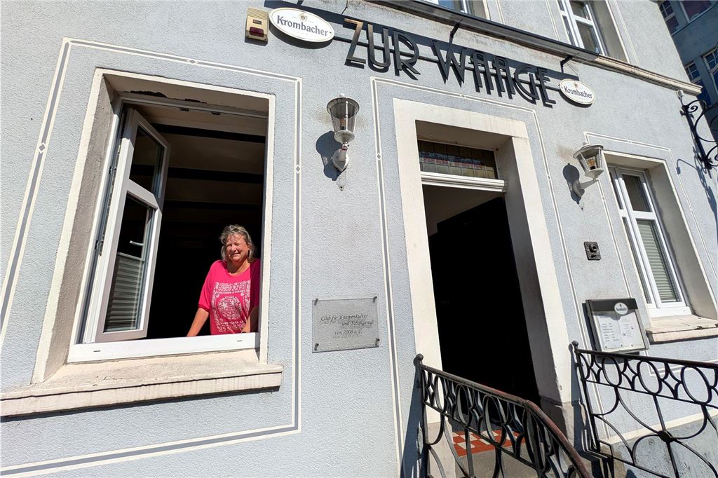 13 wilde Jahre in der „Waage“: Wirtin Sylvia Schülke lädt zur Feier Eine Wirtin schaut aus dem geöffneten Fenster ihrer Kneipe heraus.